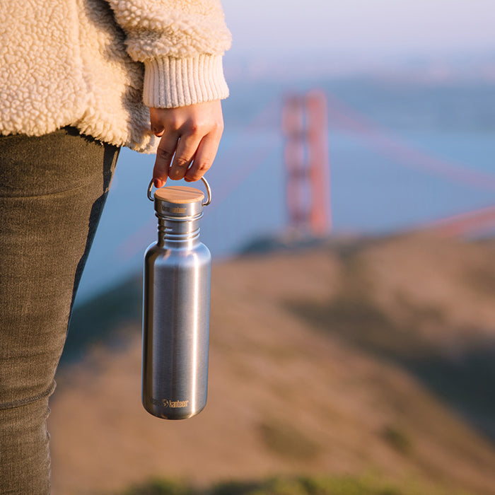 27oz-reflect-with-bamboo-cap-v5 K27SSLRF-BS-BAMBOO_reflect_bottle_bridge_lifestyle.jpg
